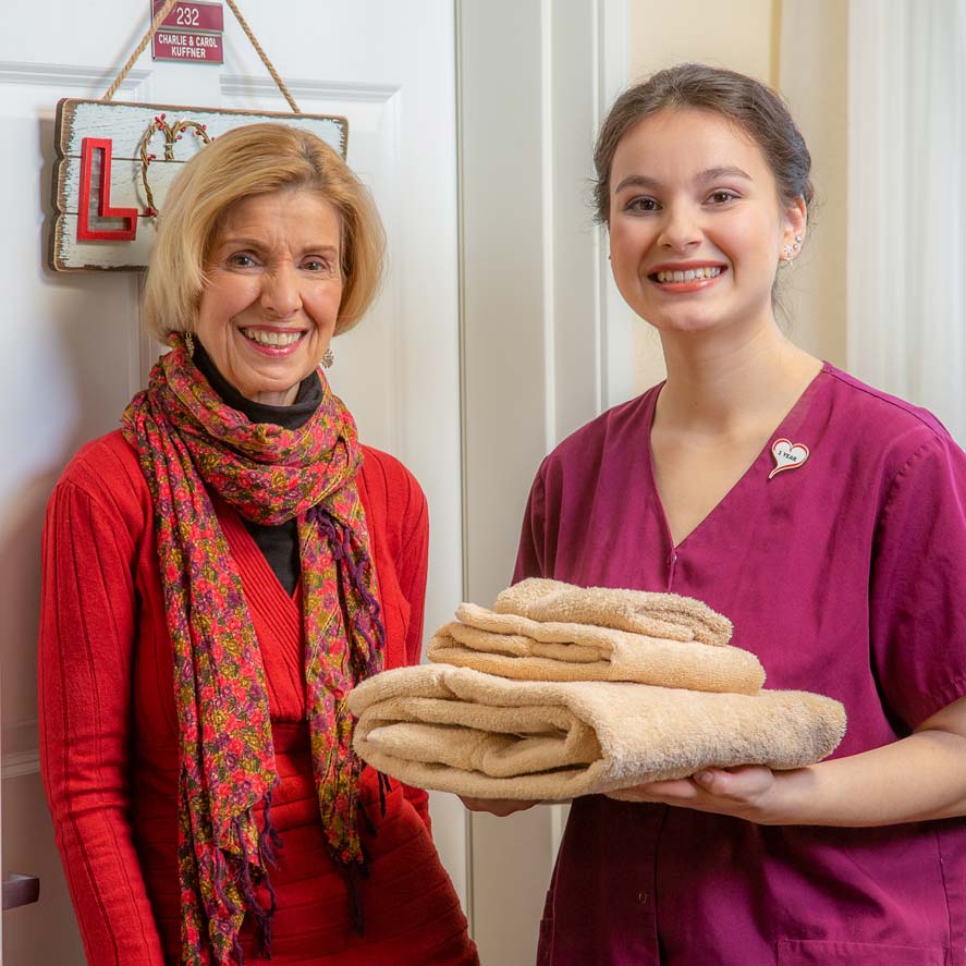 A team member delivering fresh linens to a resident at Parker Place
